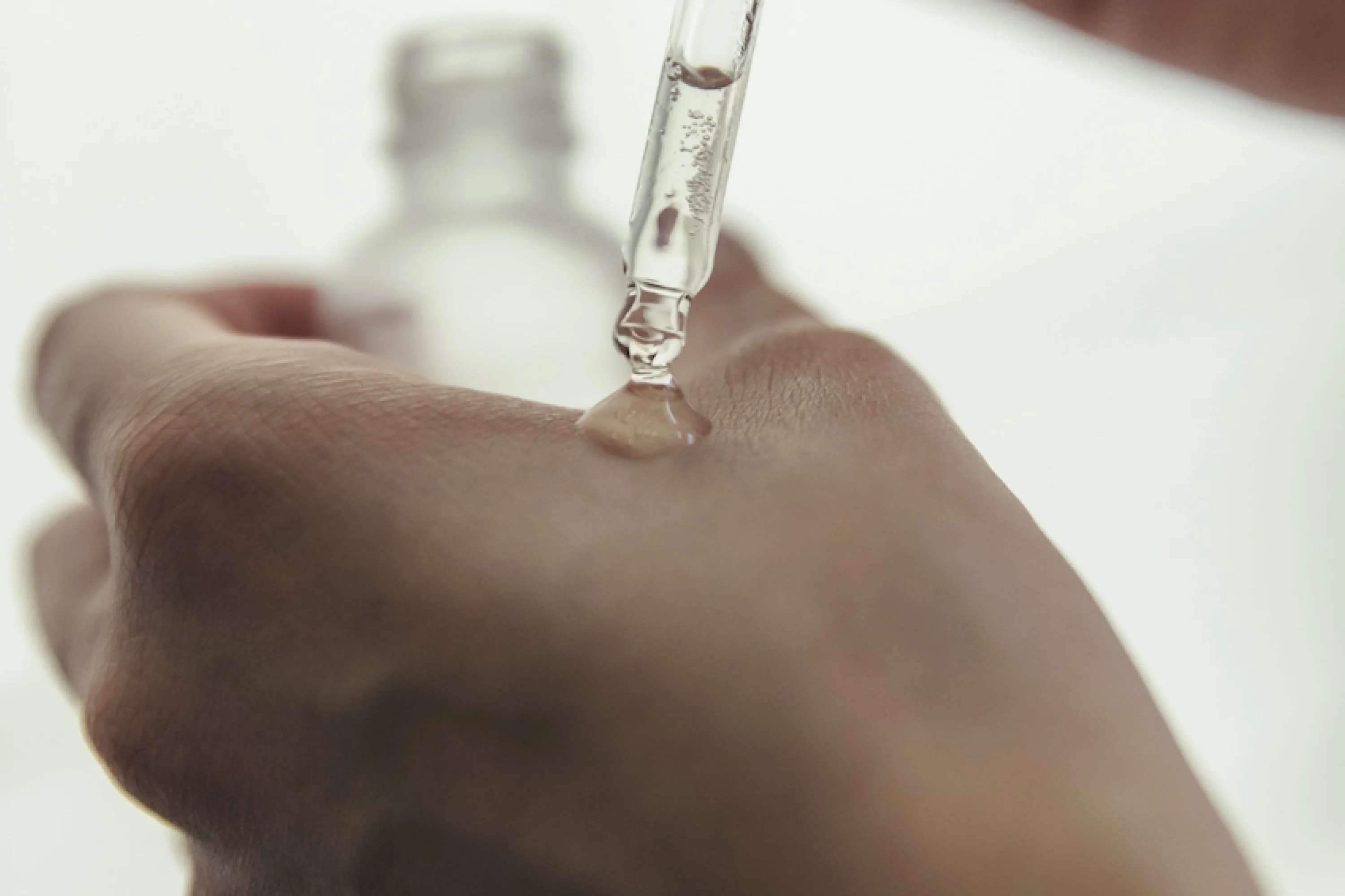 serum in a glass dropped applied to a hand